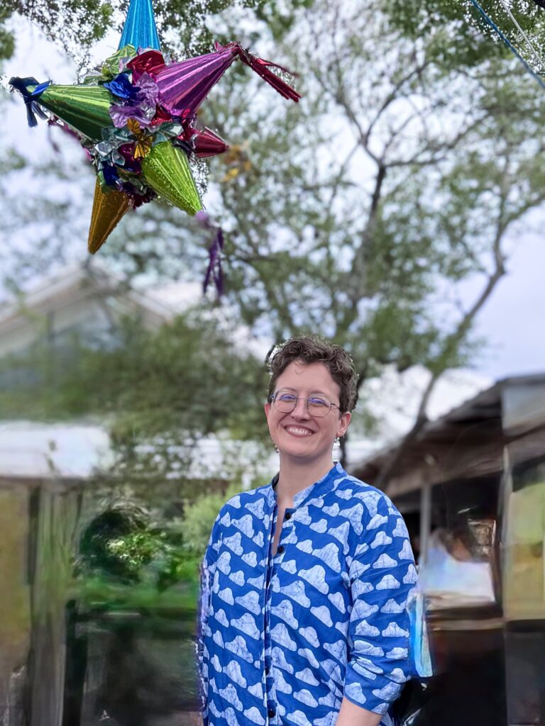 Rev. Rachael Hayes under a colorful pinata